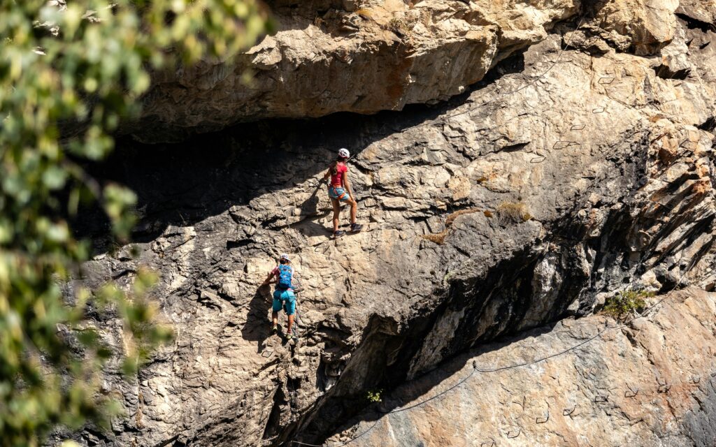 deux personnes faisant de la via ferrata en ardèche sur un bloc rocheux